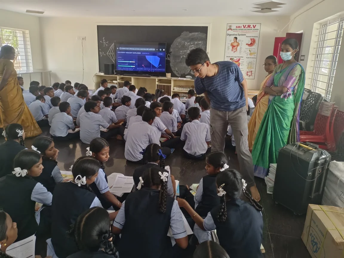 Helping seated students during a lesson with MathCore on the screen.